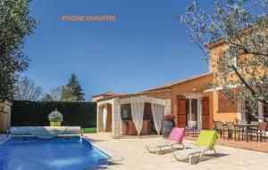 una casa con piscina y 2 sillas de césped en VILLA FLAMENCA - piscine chauffée en Châteaurenard
