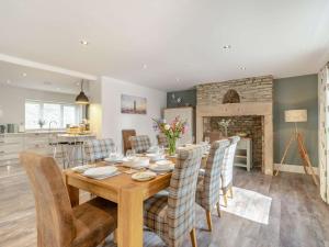 a dining room and kitchen with a wooden table and chairs at 4 Bed in Hexham 87458 in Catton