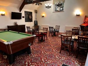 a room with a pool table and tables and chairs at The Ancient Mariner in Nether Stowey