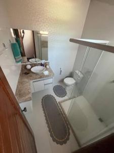 y baño con 2 lavabos, aseo y espejo. en Casa de Praia Coroa Vermelha, en Santa Cruz Cabrália