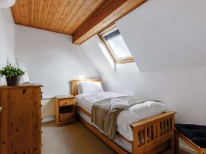 ein Schlafzimmer mit einem Bett und einem Fenster im Dachgeschoss in der Unterkunft 3 Bed in Cirencester HIC02 in South Cerney