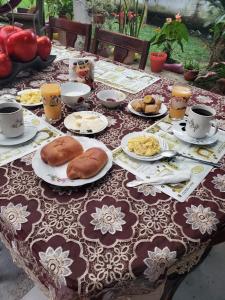 Cabañas San Diego في Macas: طاولة مع أطباق من الطعام وأكواب من القهوة