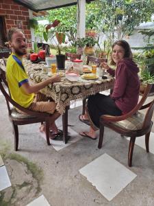 mężczyzna i kobieta siedzący przy stole w obiekcie Cabañas San Diego w mieście Macas