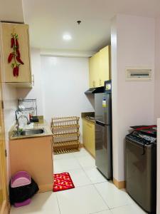 una pequeña cocina con fregadero y nevera. en Eumins Place en Manila