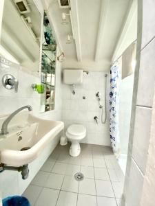 uma casa de banho branca com um lavatório e um WC em Palazzo Pandolfini's City-View Studios em Florença