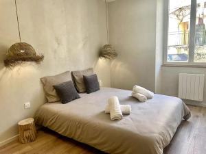 ein großes Bett mit drei Kissen darauf in einem Zimmer in der Unterkunft Cosy ANELA in Saint-Claude
