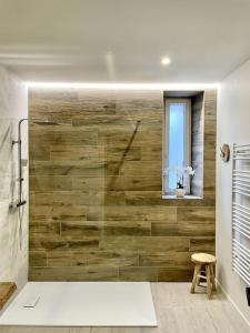 ein Badezimmer mit einer Holzwand und einem Fenster in der Unterkunft Cosy ANELA in Saint-Claude