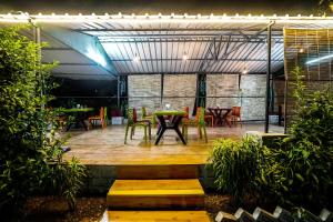 a patio with a table and chairs and lights at The Forest Lake View Resort in Panchkula