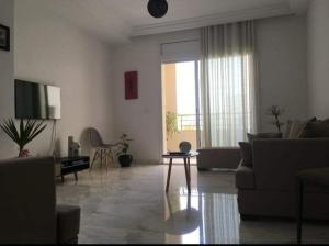 een woonkamer met een bank en een tafel bij Appartement Luxe in Tunis