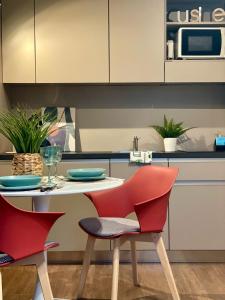 una cucina con tavolo con due sedie e forno a microonde di Bnbook Expo Residence Rho a Rho