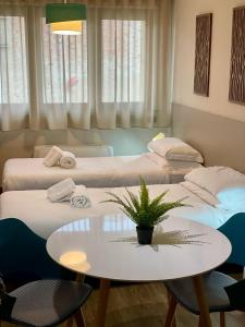Habitación de hotel con 2 camas, mesa y mesa en Bnbook Expo Residence Rho, en Rho