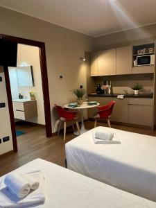 una camera d'albergo con letto, tavolo e cucina di Bnbook Expo Residence Rho a Rho