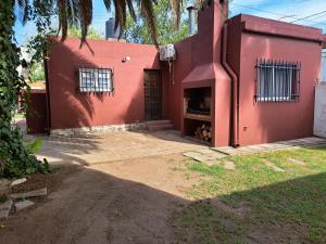 a red house with a red wall and windows at Casa Bordó Villa Allende in Villa Allende
