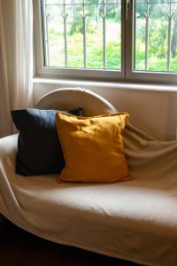 a couch with two pillows sitting under a window at Garden House in Cascais