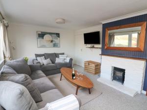 a living room with a couch and a fireplace at 8 Little Hill in Salcombe