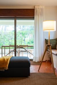 a living room with a lamp and a large window at Garden House in Cascais