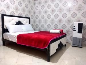 um quarto com uma cama com um cobertor vermelho em Aziz House 2 em Tan-Tan