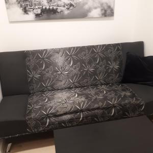 a black couch with a black and white wallpaper at Mini apart Žvėrynas in Vilnius