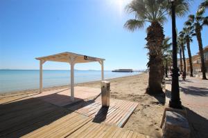 un refugio en una playa con palmeras y el océano en Casa Meroño Los Alcazares en Los Alcázares