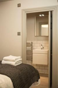 a bathroom with a bed and a sink and a mirror at Artizan's Nest - central, Scandi style in Bath