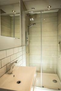 a white bathroom with a shower and a sink at Artizan's Nest - central, Scandi style in Bath