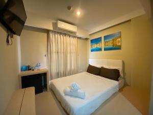 una camera da letto con un letto bianco con una scatola blu sopra di Kimono Spa Hotel a Kuta