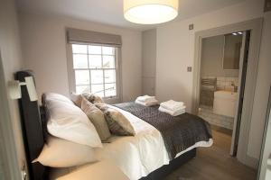 ein Schlafzimmer mit einem Bett mit Kissen und einem Fenster in der Unterkunft Artizan's Nest - central, Scandi style in Bath
