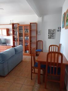 sala de estar con sofá, mesa y sillas en La Palanca Solo Familias, en Playa de Xeraco