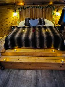 un grande letto con un piumone nero e luci sopra di Lovers Nest a Urbès