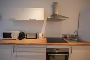 a kitchen with a counter with a microwave and a sink at Equipped apartment premium location in Lille