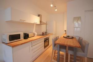 a small kitchen with a table and a microwave at Equipped apartment premium location in Lille