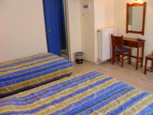 a bedroom with a bed and a desk and a chair at Katia Hotel in Afissos