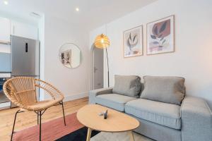 ein Wohnzimmer mit einem Sofa und einem Tisch in der Unterkunft Bright 3-bedroom 2-bathroom flat in Lille