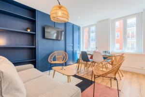 Una sala de estar con un sofá y sillas y una mesa. en Bright 3-bedroom 2-bathroom flat, en Lille