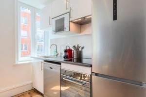 a kitchen with a stainless steel refrigerator and a sink at Bright 3-bedroom 2-bathroom flat in Lille