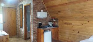 eine Küche mit einer Theke in einem Zimmer mit Holzwänden in der Unterkunft Chale com hidromassagem da Vick in Campos do Jordão