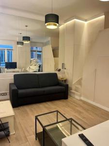 a living room with a black couch and a glass table at Élégance, 4 Pers, palais des congrès in Paris