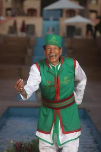 Hotel Prestige Agadir Boutique & SPA في أغادير: رجل كبير في السن يرتدي قبعة خضراء وزي موحد
