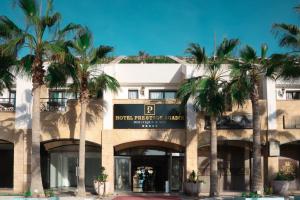 a building with palm trees in front of it at Hotel Prestige Agadir Boutique & SPA in Agadir