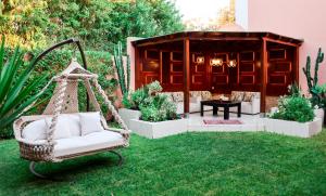 a hammock in a yard with a table and chairs at Hotel Prestige Agadir Boutique & SPA in Agadir