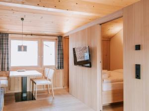 レッヒにあるAlpina Lech - natural livingのテーブルとベッド、窓が備わる客室です。