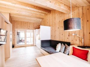 ein Wohnzimmer mit Holzwänden und einem Sofa in der Unterkunft Alpina Lech - natural living in Lech am Arlberg