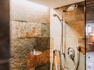 baño con ducha y puerta de cristal en Alpina Lech - natural living, en Lech am Arlberg