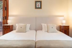 2 camas con sábanas blancas y almohadas en una habitación en Casa da Fajã Alta by An Island Apart, en Jogo da Bola