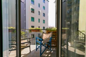 una silla azul en un balcón con un edificio en Private parking - Family home - 15 min to Venice en Mestre