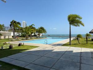 ヌエバ・ゴルゴナにあるMahi Mahi Apartment - Gorgonaのヤシの木と海のスイミングプール
