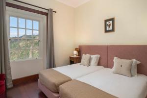 - une chambre avec 2 lits et une fenêtre dans l'établissement Casa da Fajã Alta by An Island Apart, à Jogo da Bola