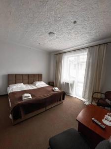 a bedroom with a large bed and a window at Hotel Continent in Polyana