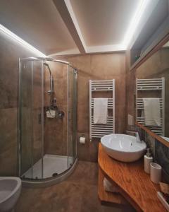 a bathroom with a glass shower and a sink at Etesia Vacation Home in Acitrezza