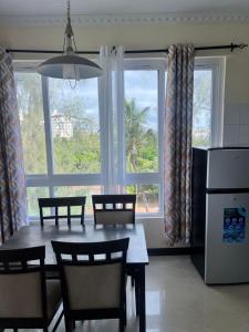 a dining room with a table and chairs and windows at Waves and Wanderlust- Nyali Sunrise in Nyali